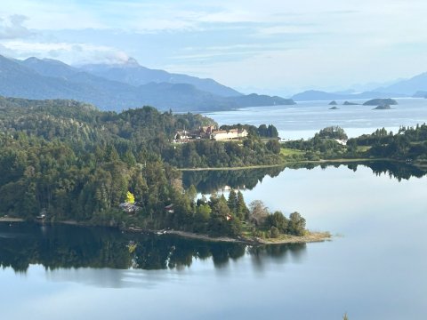 Serene waters wind through Bariloche's forested landscape